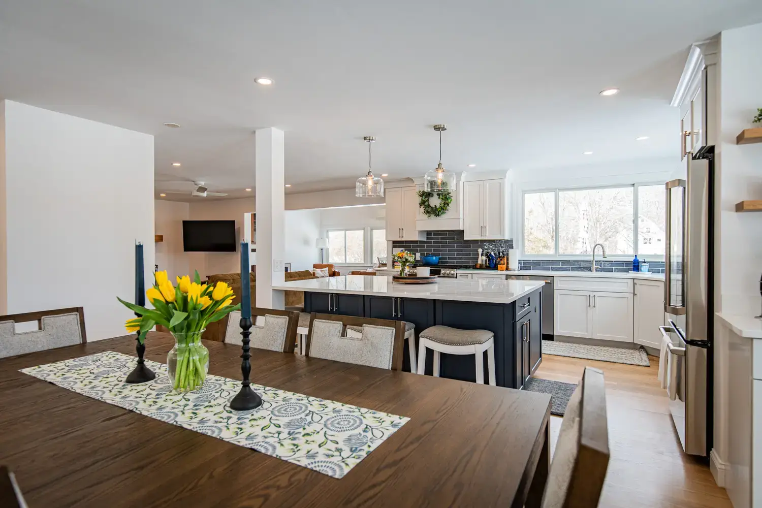 Bright white kitchen with dining area from a completed Clarke Building Company remodel in West Newbury